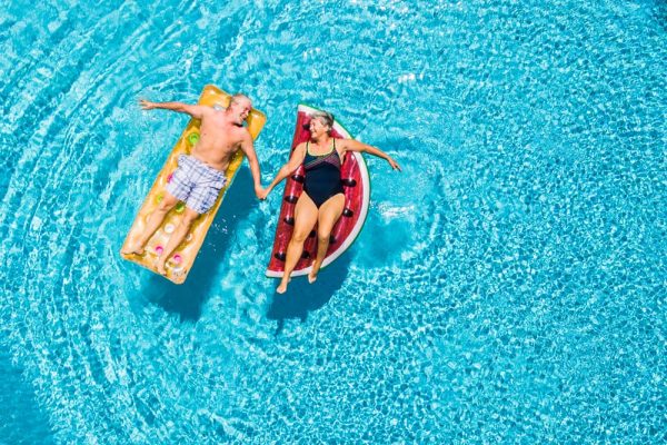 Retired couple enjoying a holiday by the pool, representing the benefits of boosting your pension for a comfortable retirement.