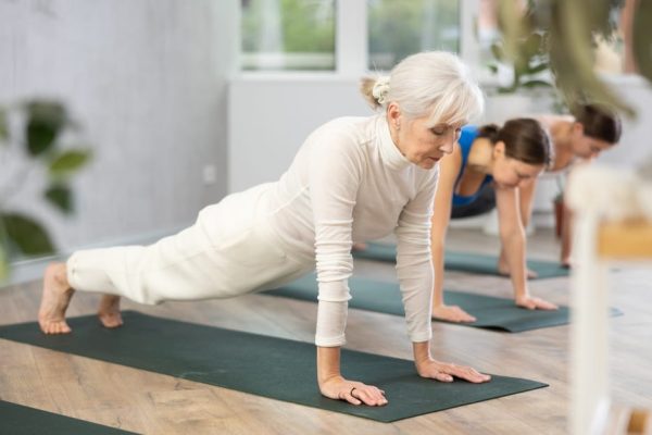 Older woman practicing yoga outdoors, representing active retirement and healthy lifestyle in later life