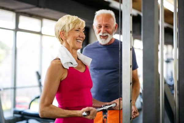 Two older adults working out at the gym, representing an active lifestyle in retirement supported by smart financial planning beyond the State Pension