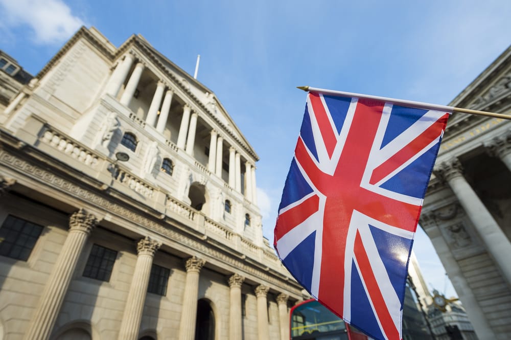 Bank of England Base Rate Cut – August 2025 Monetary Policy Decision Bank of England building with Union Jack flag flying in front, symbolising UK monetary policy