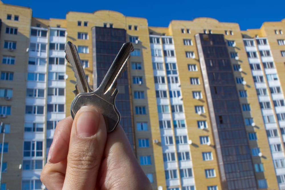 Set of house keys in front of a block of flats representing property purchase and mortgage advice in Swindon, Cirencester and Bristol.
