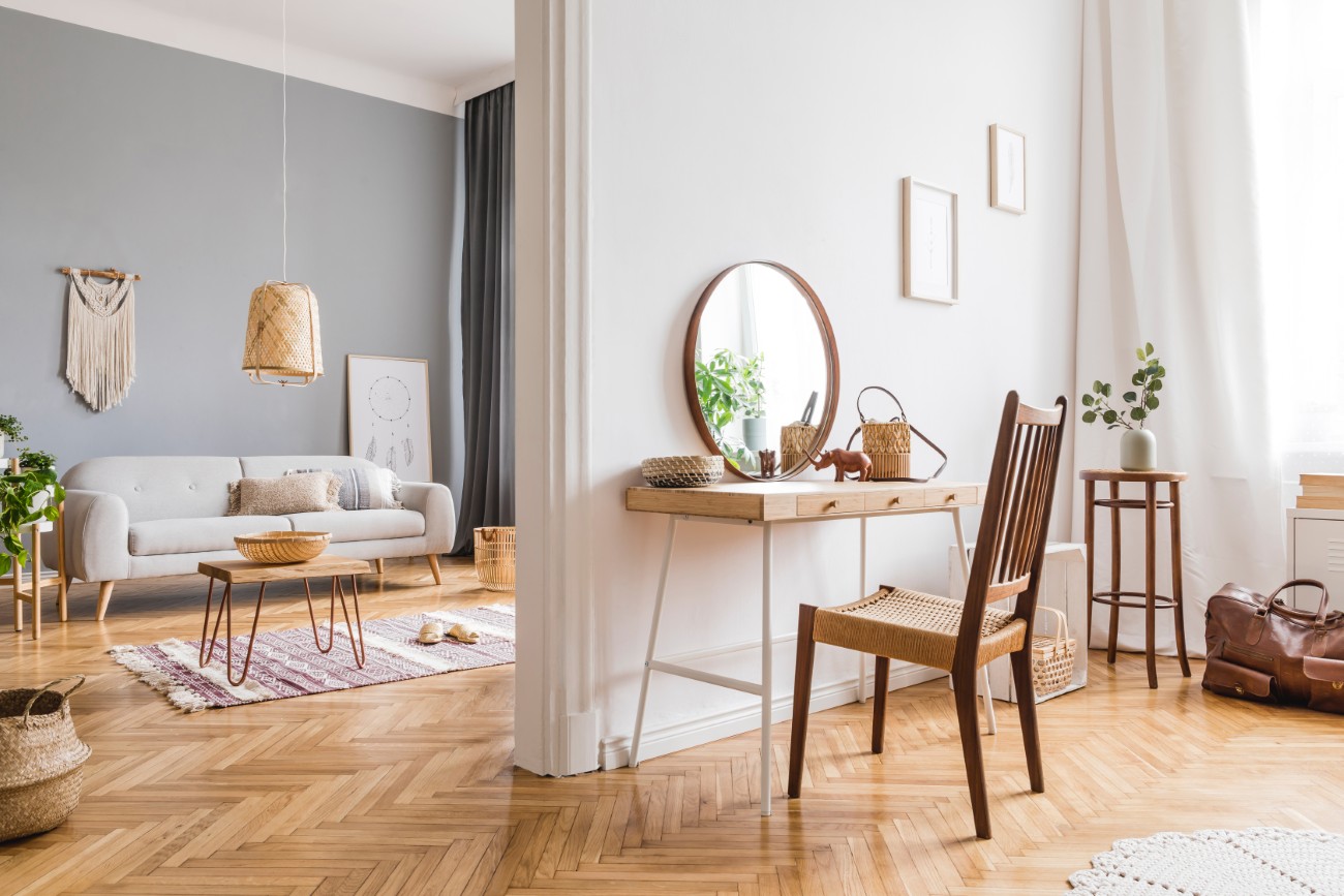 Stylish composition of creative spacious living room interior wi Stylish composition of creative spacious living room interior with mock up poster frame, commode, mirror, plants, carpet and accessories. White walls and parquet floor. Template