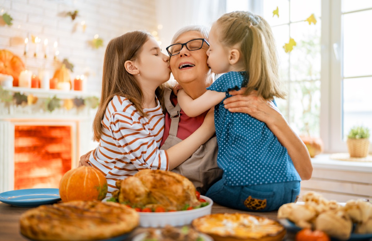 Happy Thanksgiving Day! Happy Thanksgiving Day! Autumn feast. Family sitting at the table and celebrating holiday. Traditional dinner. Grandmother and granddaughters.